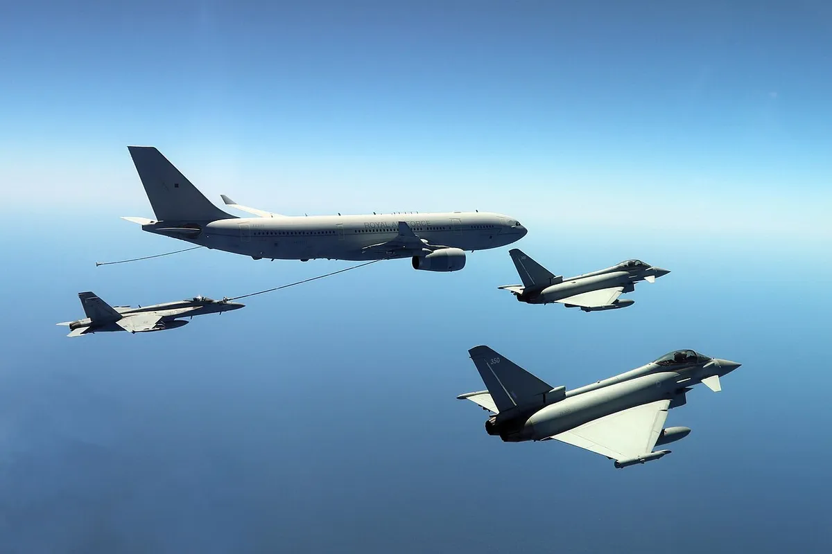 An RAF Voyager tanker with a U.S. Navy F/A-18E and two RAF Typhoons in formation over the sea
